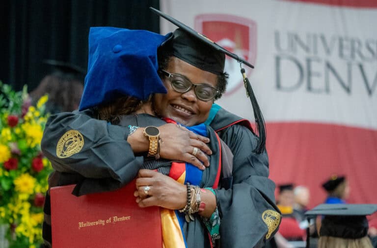 Two people hugging at a commencement ceremony.