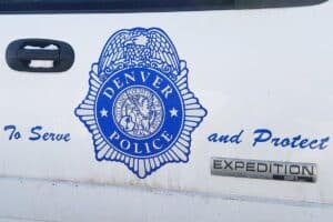 The Denver Police Department crest is shown on a squad car. 