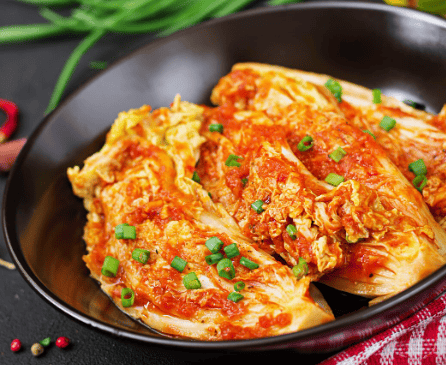 A plate of freshly made Korean kimchi with bright red chili seasoning.