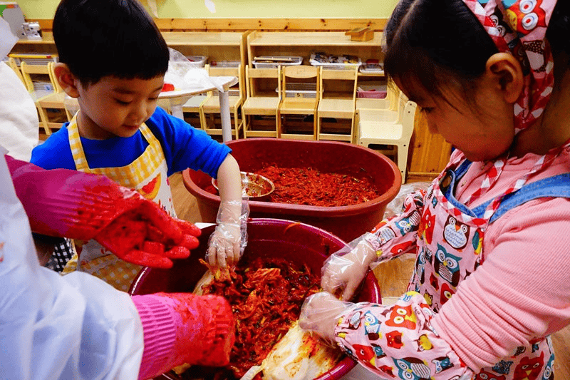 Korean families preparing kimchi together during kimjang.