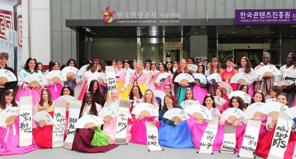 Fans holding banners and cheering together at a K-Pop concert.
