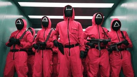 Masked guards from Squid Game standing in formation.