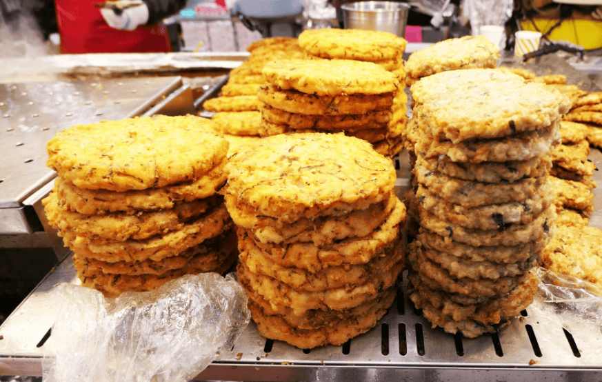 Vendor frying bindaetteok mung bean pancakes at Gwangjang Market.