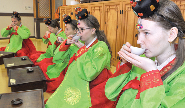 Korean tea ceremony with traditional teaware and careful pouring.