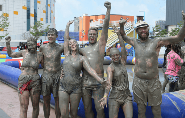 Tourists covered in mud enjoying the Boryeong Mud Festival.