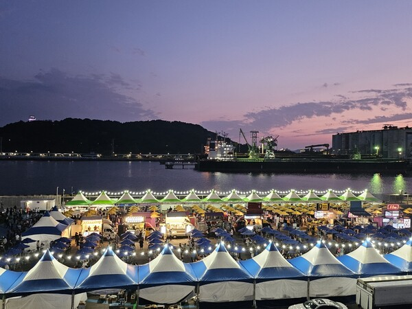 Korean night market near a festival with food stalls and lights.