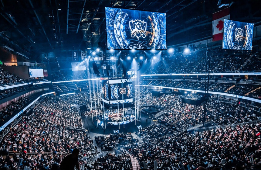 Professional esports players competing on stage with large audience.