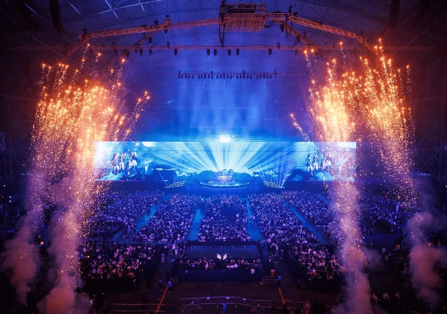 Professional esports players competing on stage with large audience.