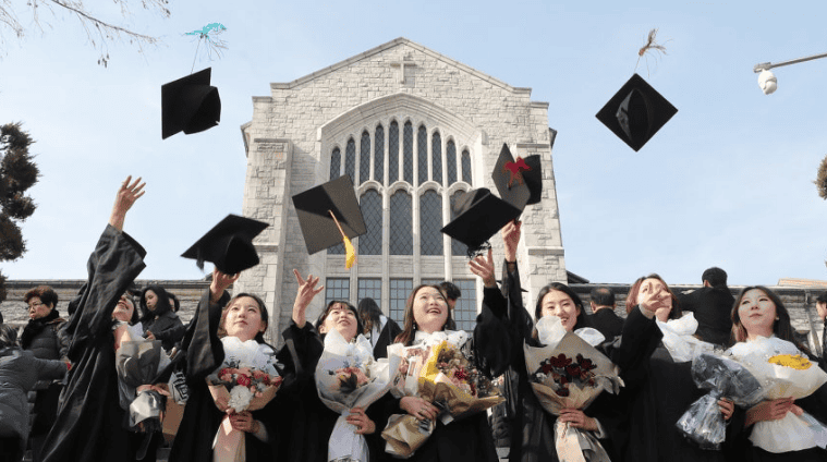 Korean students throwing graduation caps in celebration.