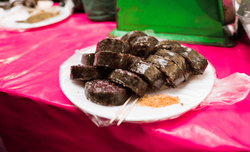 A plate of sliced Korean sundae sausage with dipping salt on the side.