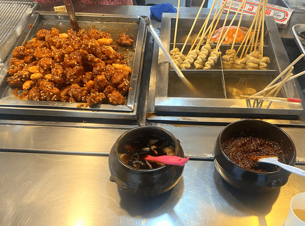 A paper cup filled with Korean sweet and spicy fried chicken.
