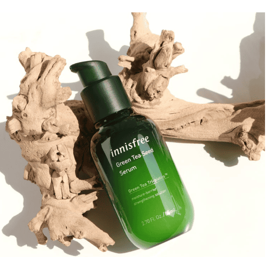 Innisfree Green Tea Seed Serum bottle with fresh leaves