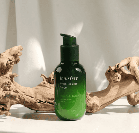 Innisfree Green Tea Seed Serum bottle with fresh leaves
