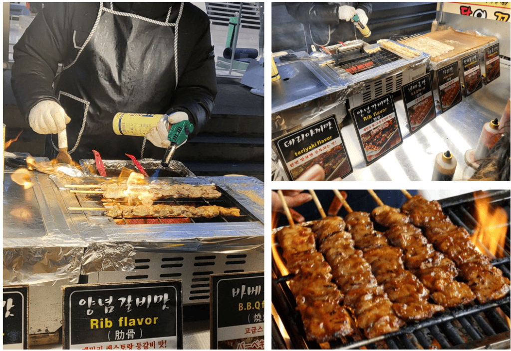 Korean chicken skewers being grilled at a street food stall.