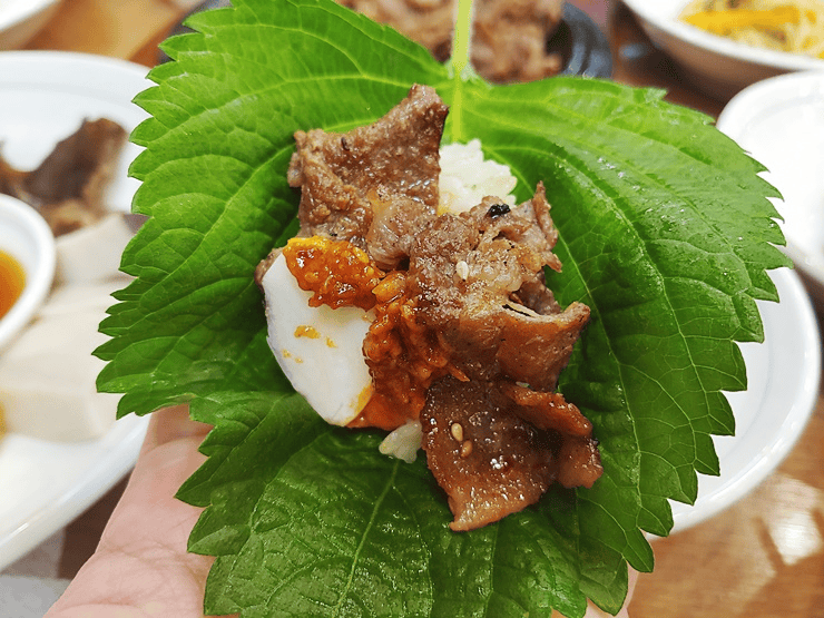 Korean lettuce wrap with grilled pork, rice, and ssamjang.