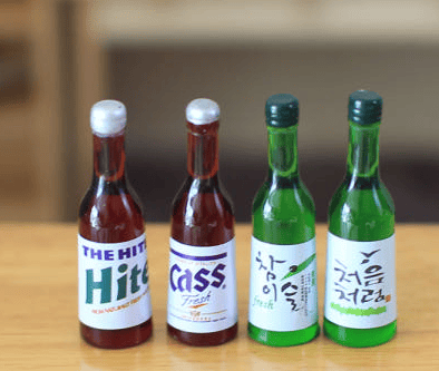Korean soju bottles and beer glasses on a BBQ table.
