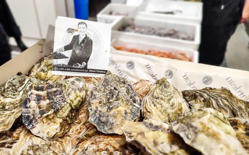 Caja de ostras frescas Gillardeau recién abierta mostrando la etiqueta de trazabilidad de Marie Christine y el grabado láser en la concha en KRAM.