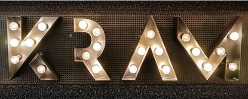 Logotipo del Restaurante KRAM en Andorra formado por letras corpóreas metálicas iluminadas de estilo industrial vintage.