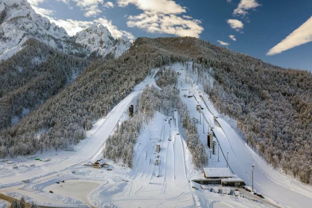 Planica nordic centre, a ski slope with snow and trees
