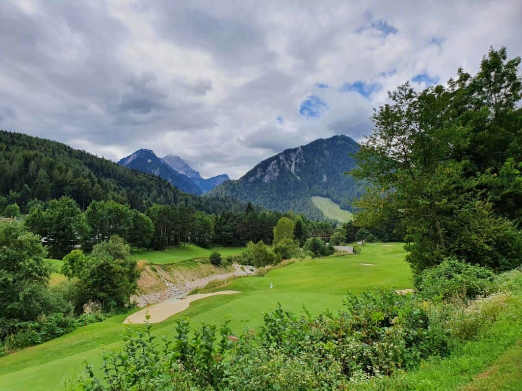 what to do in Kranjska Gora, a golf course with trees and mountains in the background
