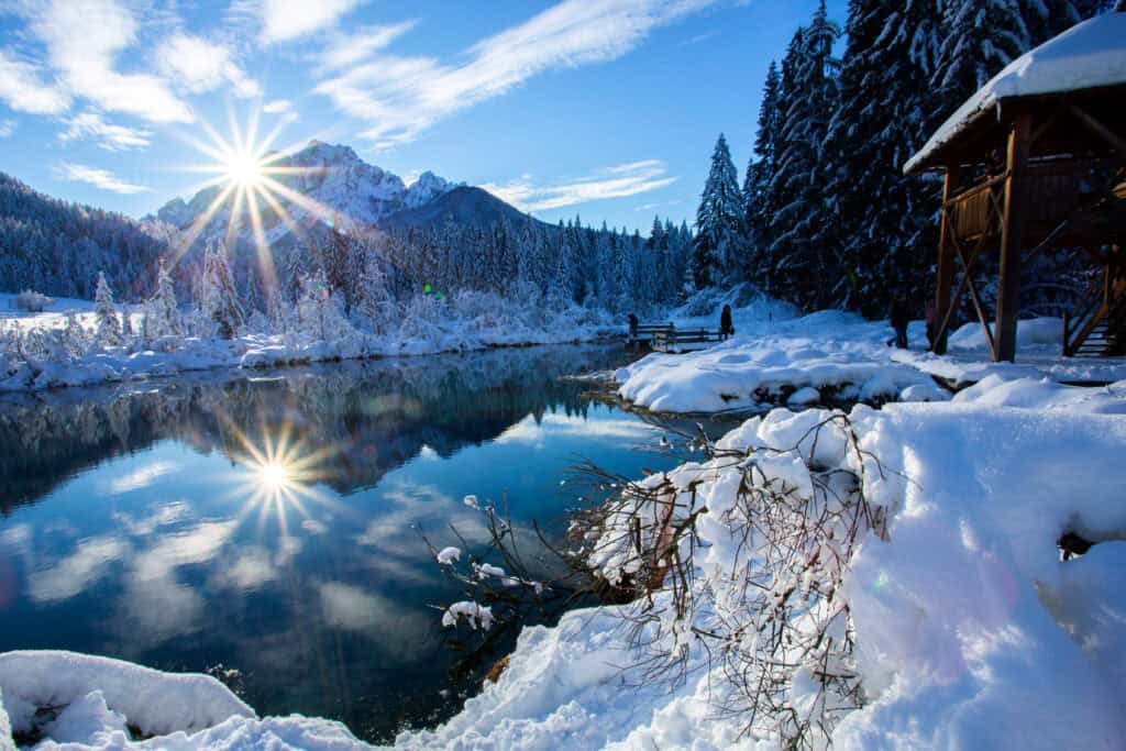 Zelenci near Kranjska Gora, a lake with snow and trees and a mountain in the background
