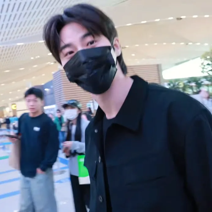Byeon Woo-seok leaning slightly toward the camera at the airport