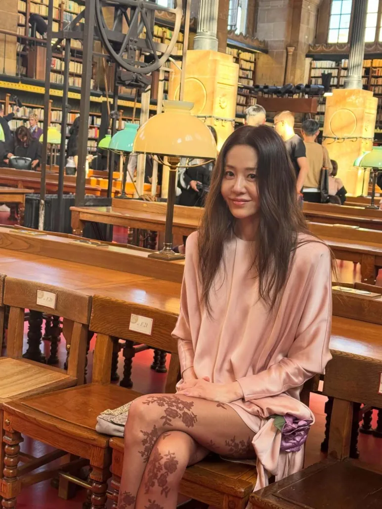 Go Hyun-jung seated in the pink dress with her bag