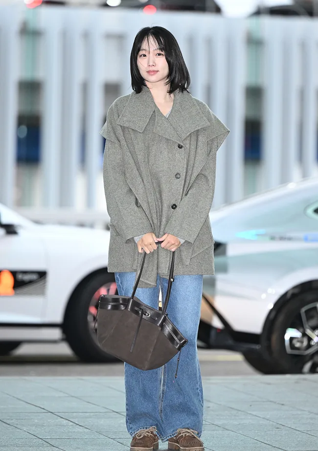 Jin Ki-joo holding a brown bag with her gray coat and blue jeans