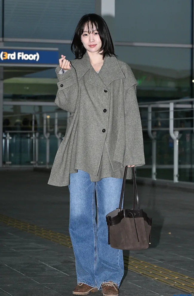 Jin Ki-joo posing at the airport with a short bob, gray coat and brown bag