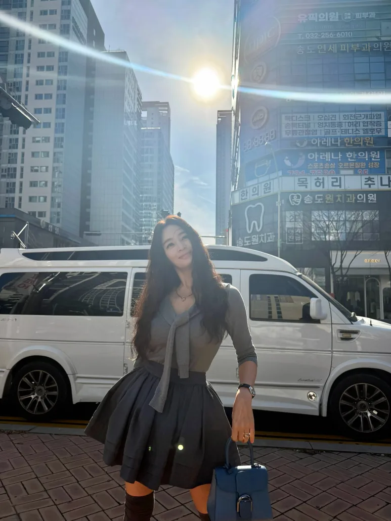 Kim Hye-soo outdoors in a gray cardigan, pleated skirt and knee-high socks