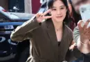 Kim Hyun-joo smiling and making a V sign outdoors