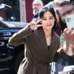 Kim Hyun-joo smiling and making a V sign outdoors
