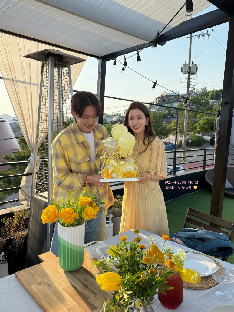 Lee Da-hae and SE7EN posing together beside a decorated table