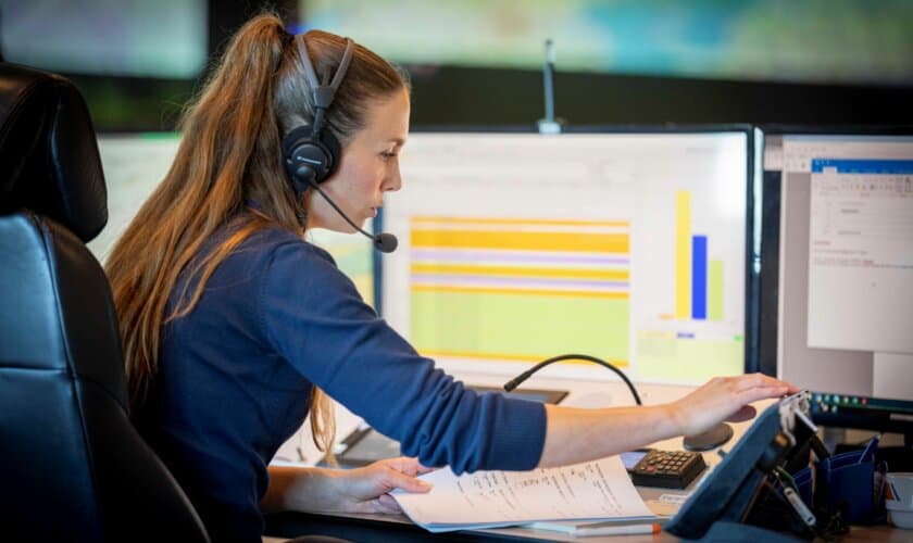 Een watch officer op het Kustwachtcentrum aan het bellen.