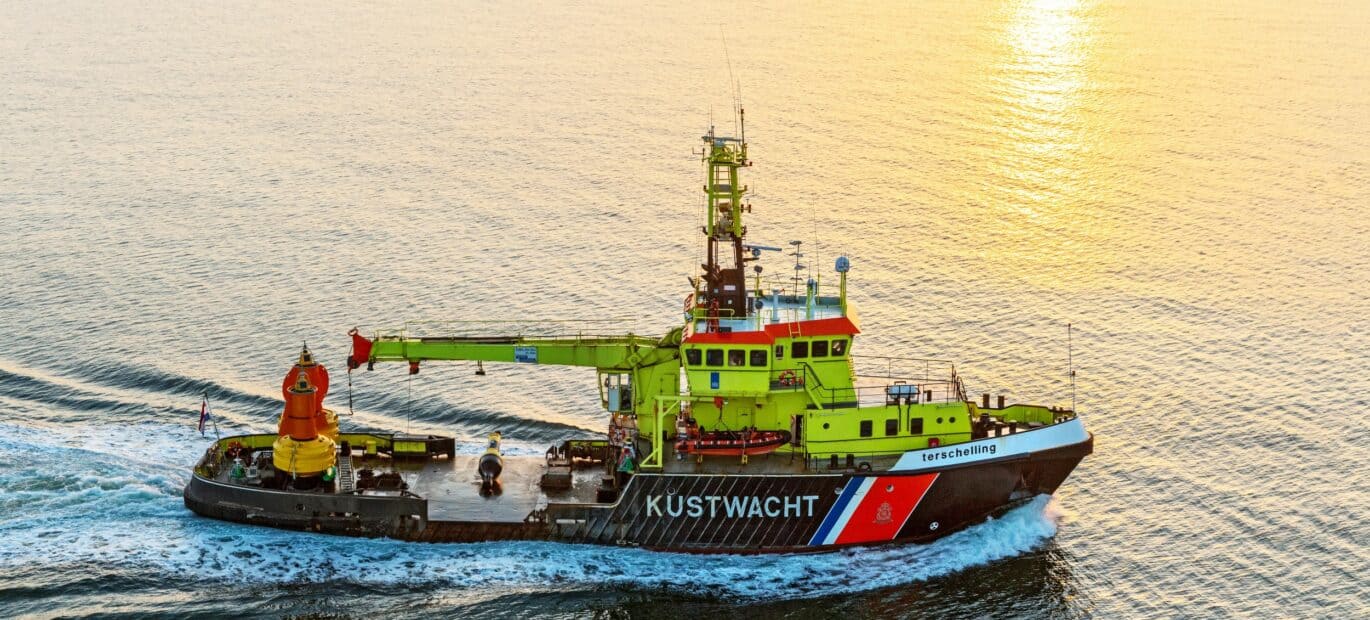Betonningsvaartuig Terschelling vaart op zee met een ondergaande zon.