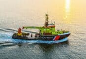 Betonningsvaartuig Terschelling vaart op zee met een ondergaande zon.