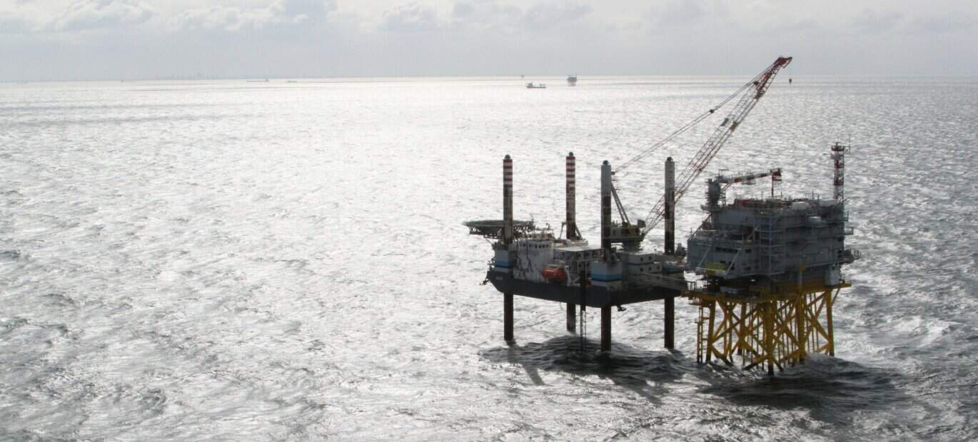 Een kraanschip is bezig met de bouw van een platform op de Noordzee.