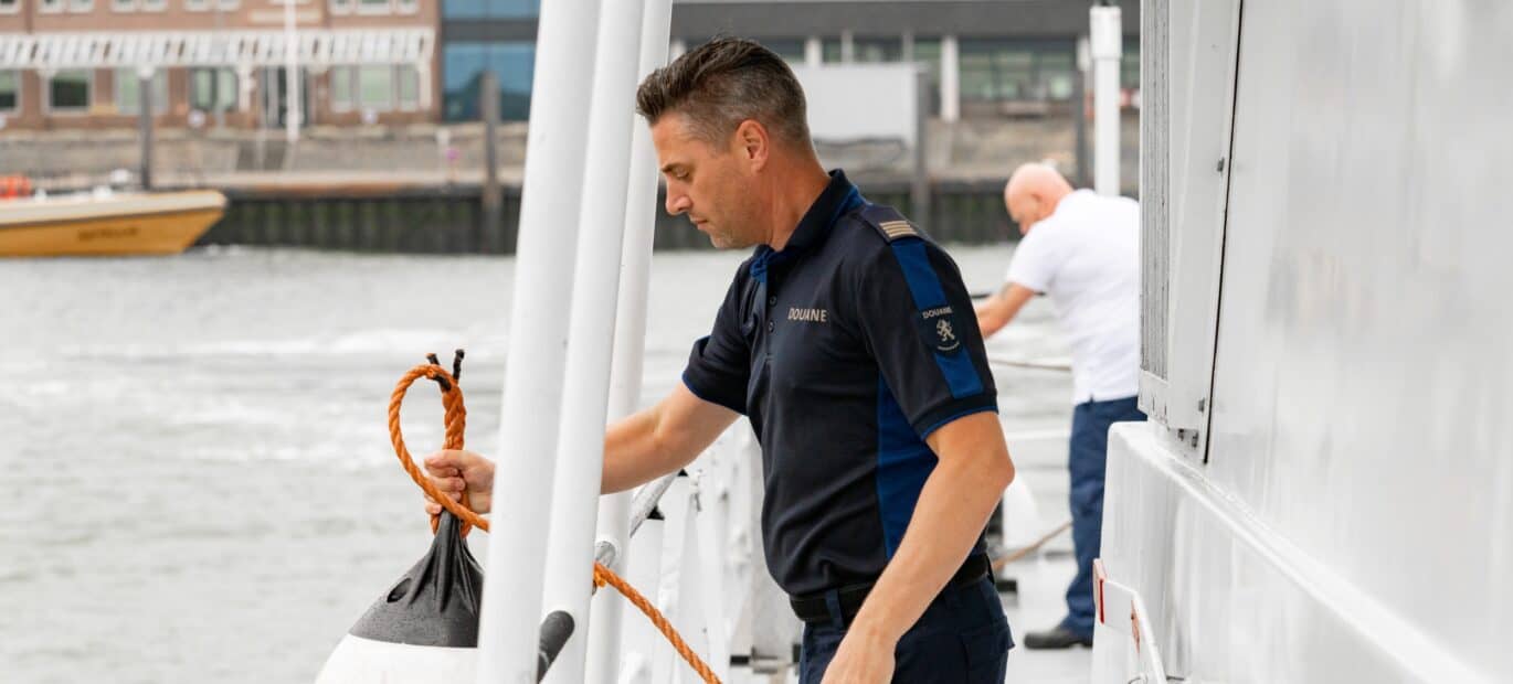 Douaneambtenaar aan het werk aan boord van een Kustwachtschip.