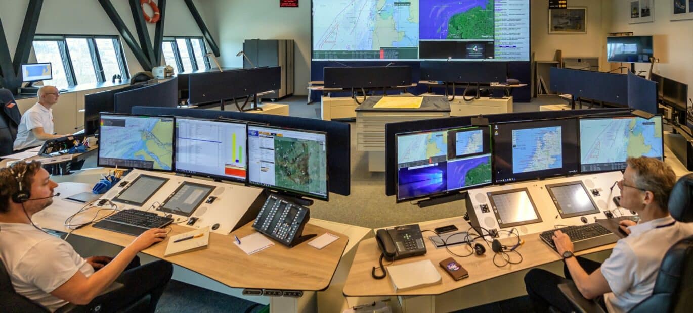 Op het Kustwachtcentrum staan meerdere tafels met schermen, informatie- en communicatiesystemen. Deze tafels staan in een cirkel.
