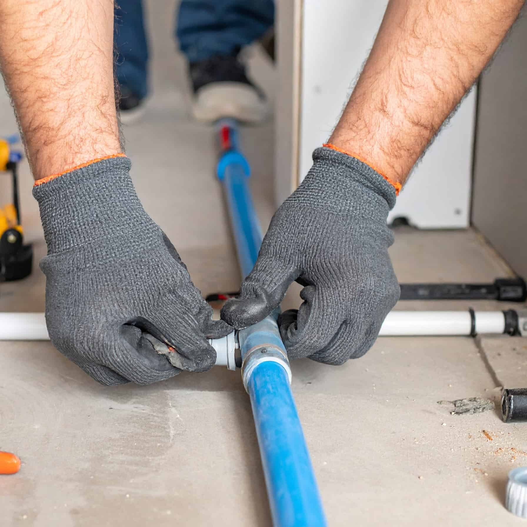 Firefly_Close-up of a professional plumber's gloved hands installing new PEX water lines insi 948928