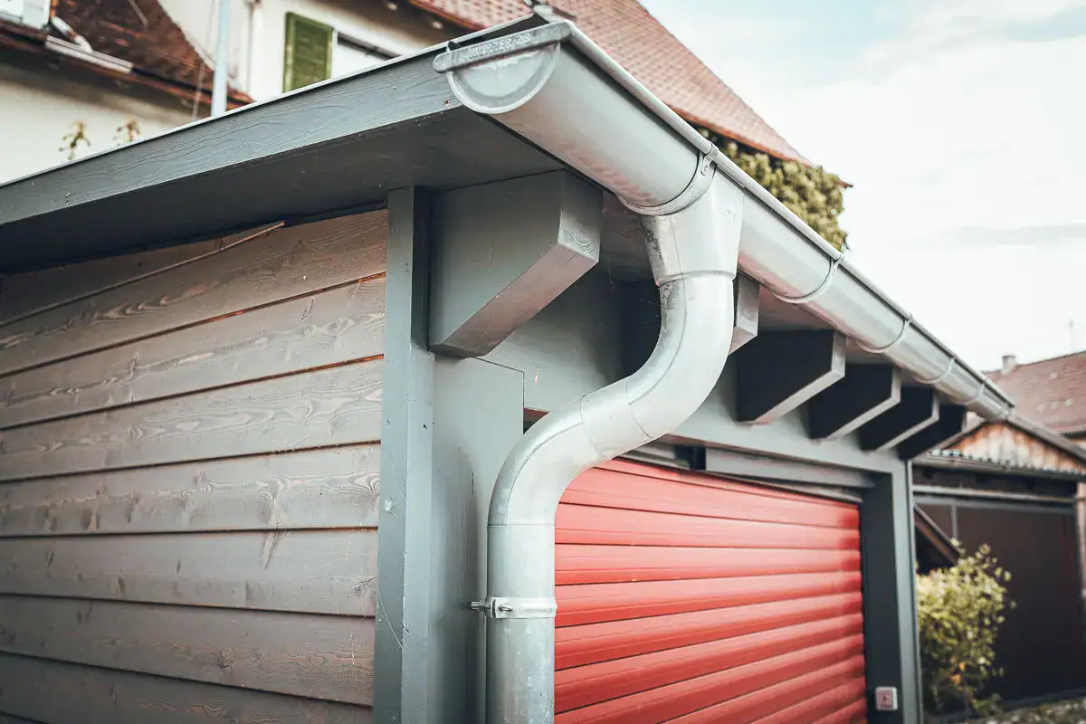 Traufdetail von Lauffers klassischem Bauprojekt: moderner Carport in Holzverschalung mit sichtbaren Sparrenköpfen.