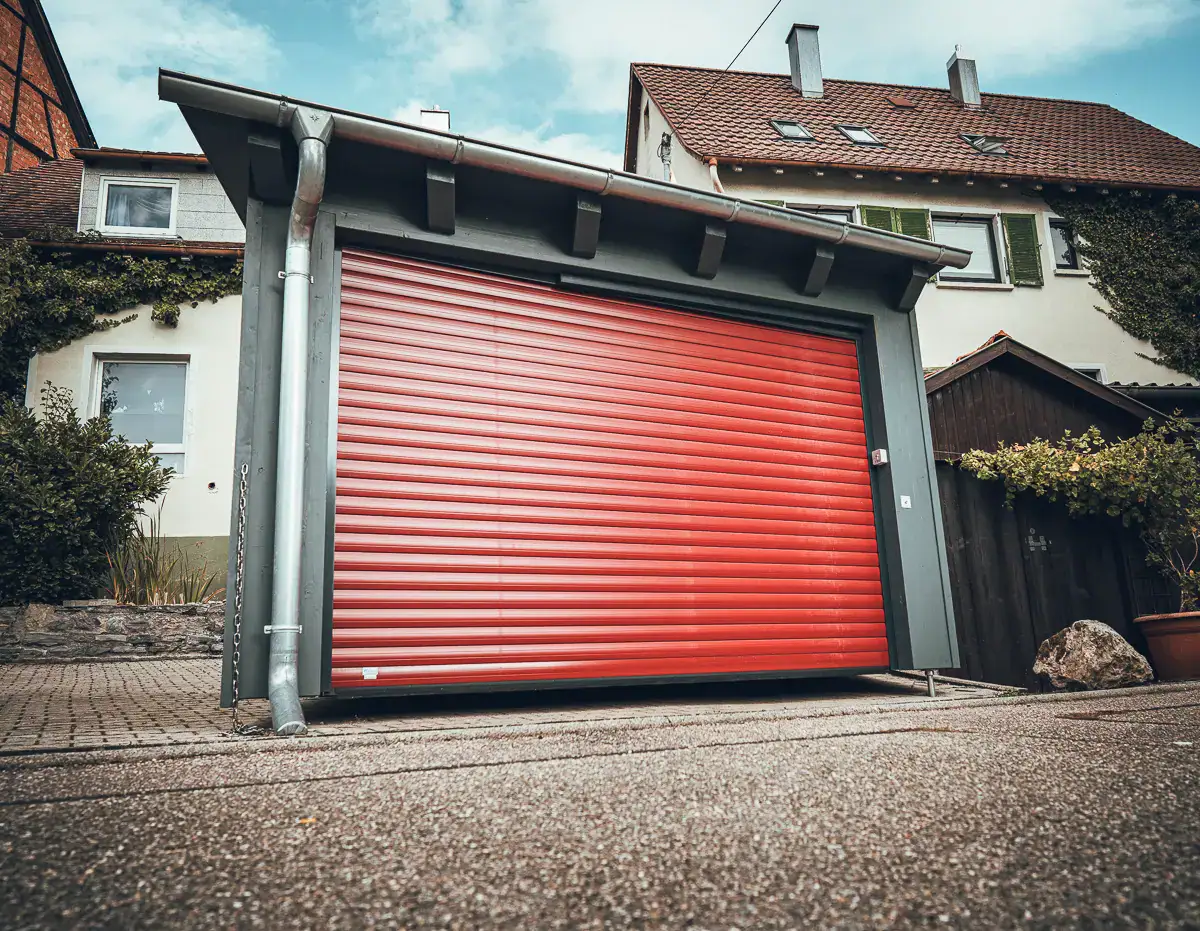 Lauffers klassisches Bauprojekt: moderner Carport in Holzverschalung mit Stützfüßen für den konstruktiven Holzschutz.