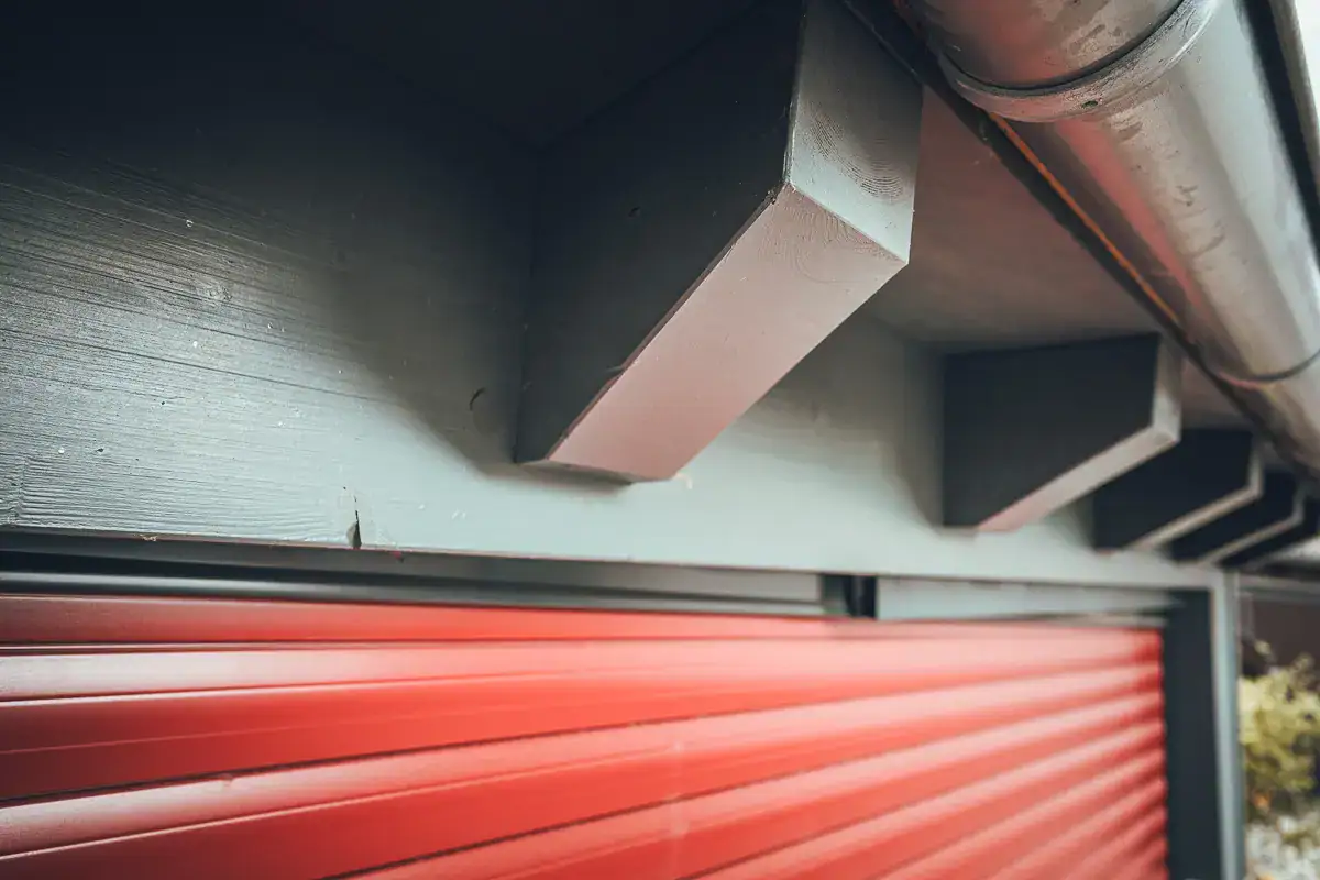Traufdetail von Lauffers klassischem Bauprojekt: moderner Carport in Holzverschalung mit sichtbaren Sparrenköpfen.