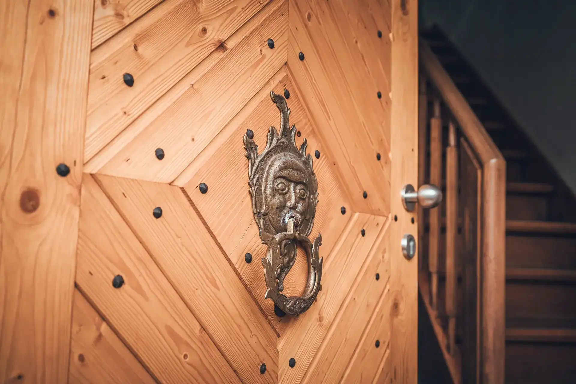 Lauffer Holzbau-Zimmerei Renningen: Wo Schreinerei und Tischlerei Hand in Hand gehen. Rekonstruierte Tür nach historischem Vorbild, historischer Türklopfer, sanierte Blockstufentreppe in Renningen.