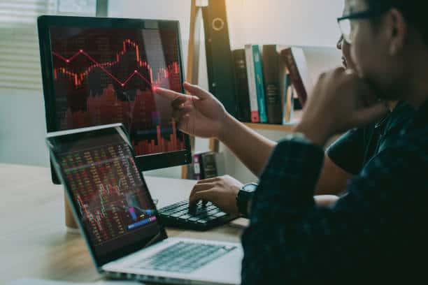 a man pointing at a graph on a computer screen