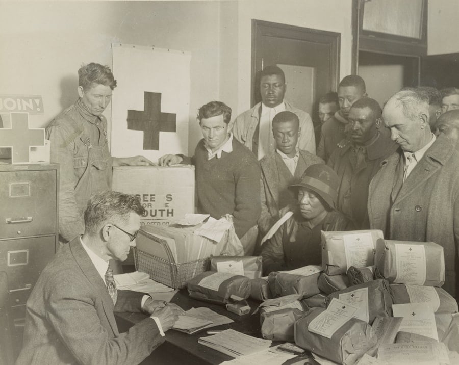 a group of people around a table with a man signing a document