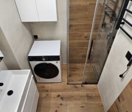 Nowoczesna łazienka po remoncie z płytkami drewnopodobnymi, betonem i kabiną walk-in. Realizacja Łazienka w 10 Dni na Bródnie.