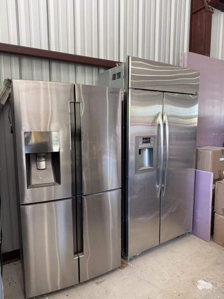 Stainless steel side-by-side refrigerators with water and ice dispensers.