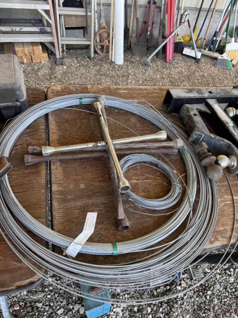 Wire fencing rolls and tools for estate auction display.