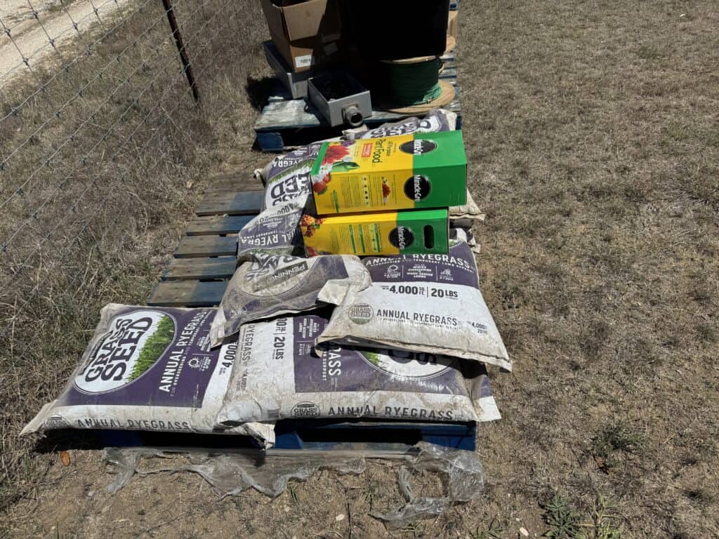 Garden soil, fertilizer, and grass seed bags displayed outdoors.